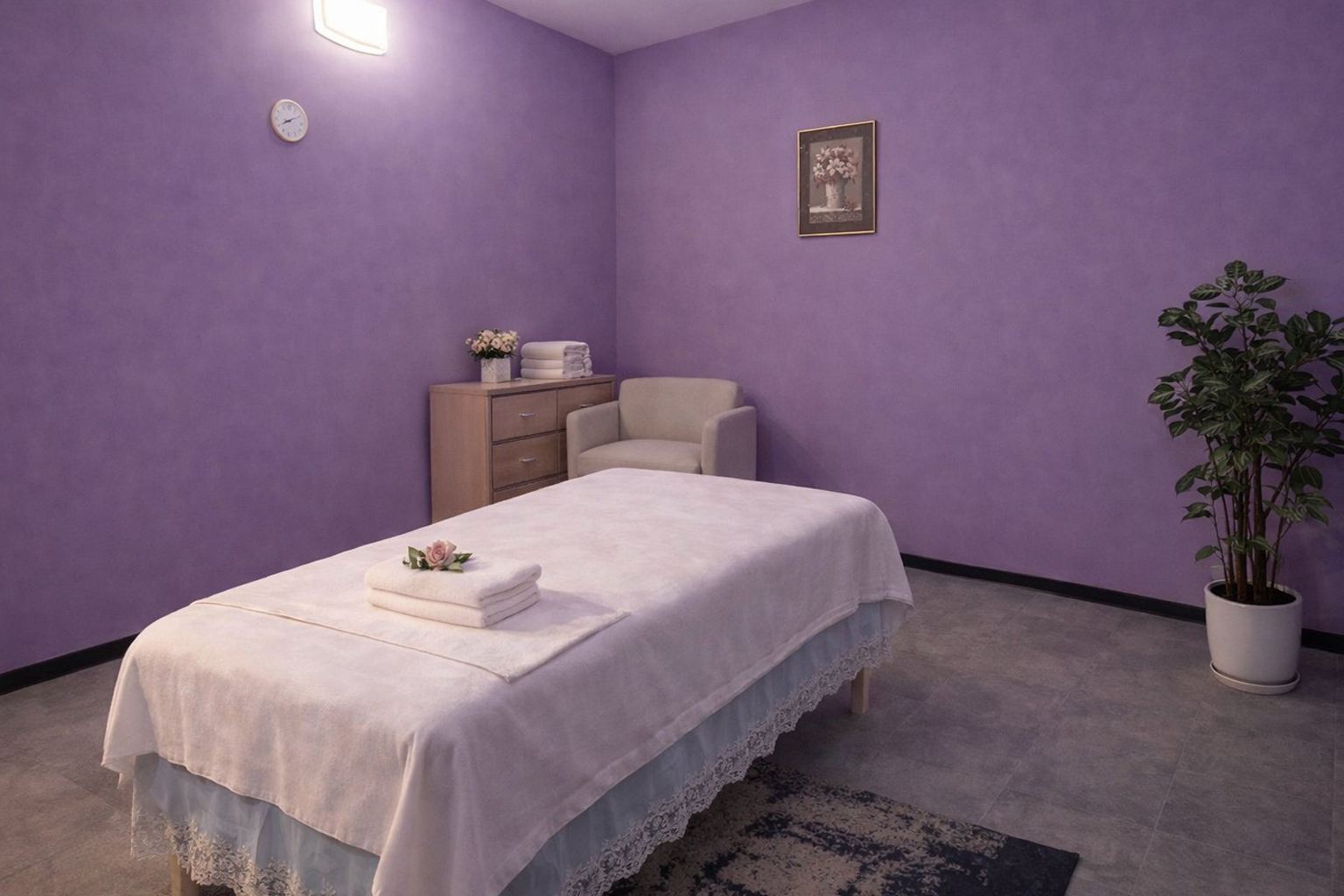 Quiet private massage room with lavender walls, lace-trimmed bedding and warm lamp at Cozy Massage Spa North Hollywood