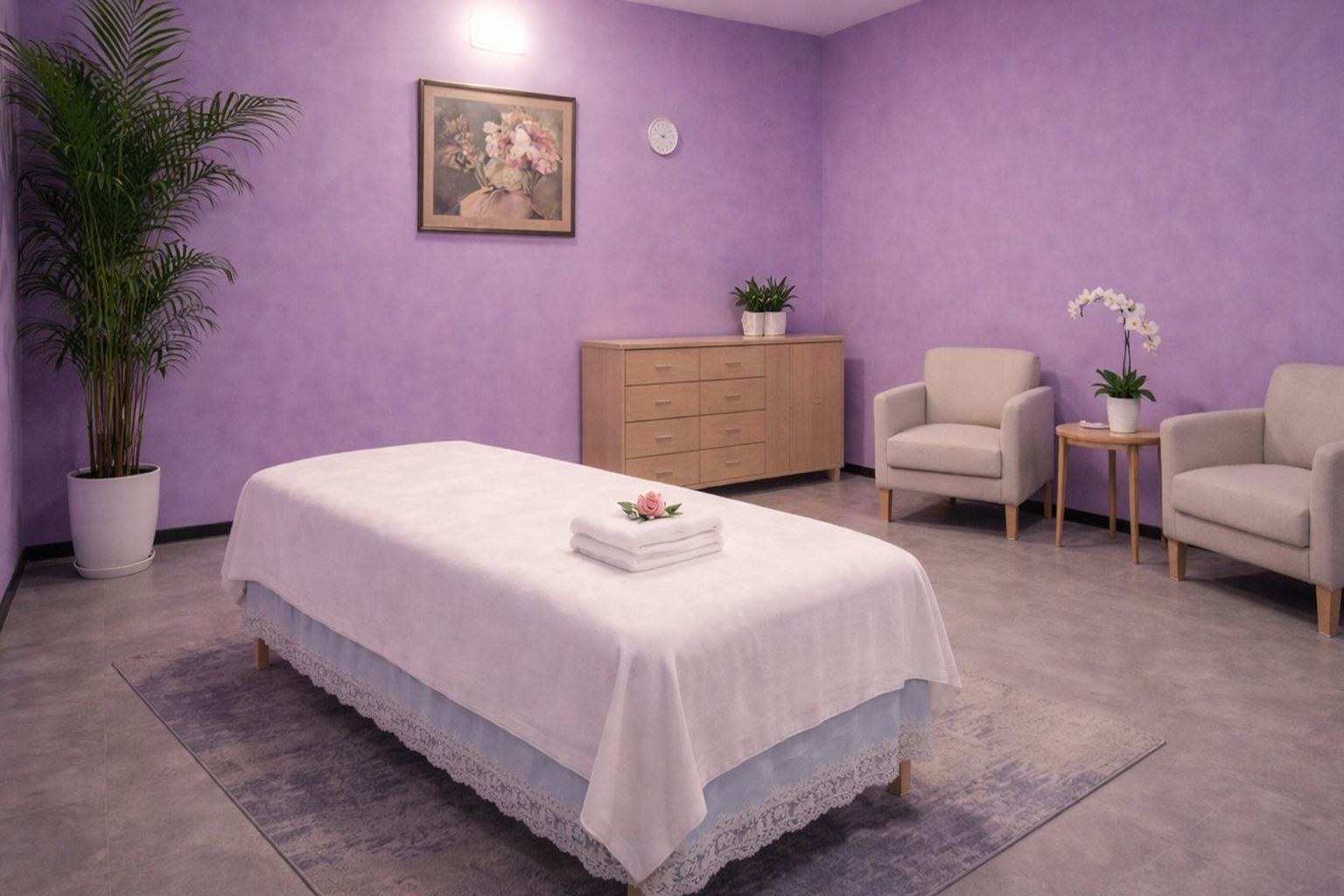 Clean private massage room with two armchairs, fresh orchid, and lavender walls at Cozy Massage Spa North Hollywood